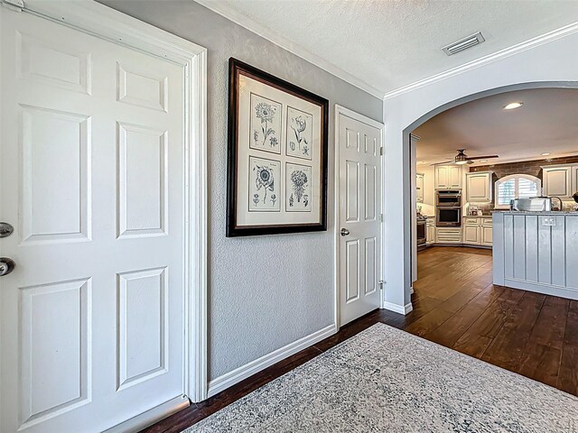 1120 81st St S, Saint Petersburg, FL 33707 - corridor with dark wood-style flooring, ornamental molding, arched walkways, baseboards, and a textured ceiling