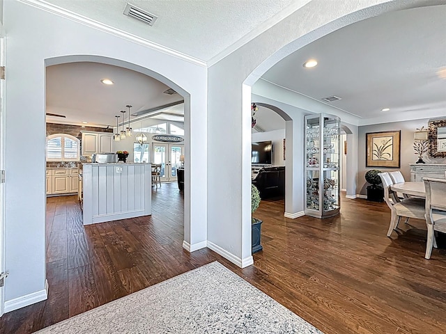 1120 81st St S, Saint Petersburg, FL 33707 - hallway with dark wood-style flooring, crown molding, baseboards, recessed lighting, and french doors