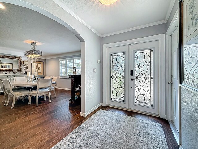 1120 81st St S, Saint Petersburg, FL 33707 - entryway featuring arched walkways, dark wood-style floors, crown molding, baseboards, and french doors