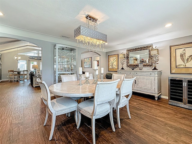 1120 81st St S, Saint Petersburg, FL 33707 - dining space featuring arched walkways, wine cooler, dark wood-style flooring, a chandelier, and recessed lighting