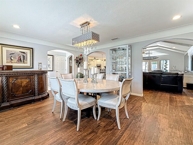 1120 81st St S, Saint Petersburg, FL 33707 - dining space featuring arched walkways, wood finished floors, a chandelier, a textured ceiling, and recessed lighting