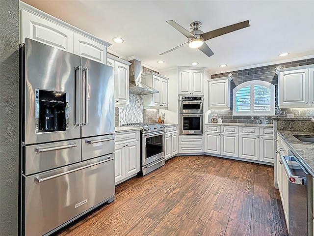 1120 81st St S, Saint Petersburg, FL 33707 - kitchen with high quality appliances, wall chimney range hood, dark wood-style flooring, a ceiling fan, and recessed lighting