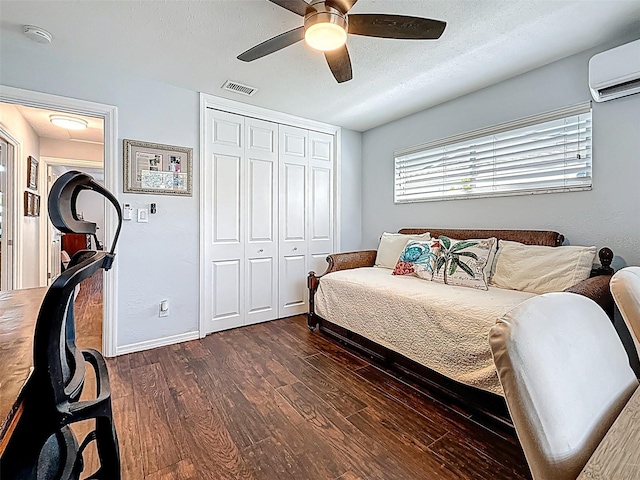 1120 81st St S, Saint Petersburg, FL 33707 - bedroom featuring a wall mounted air conditioner, dark wood-style flooring, a closet, baseboards, and a ceiling fan