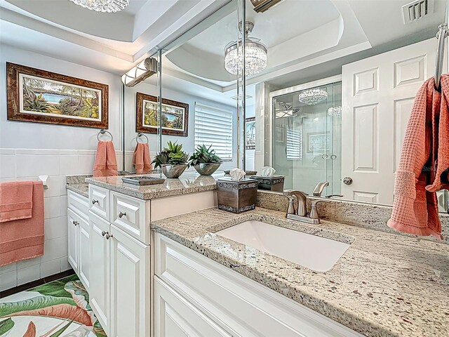 1120 81st St S, Saint Petersburg, FL 33707 - bathroom with a stall shower, vanity, a tray ceiling, and tile walls