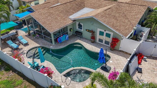 1120 81st St S, Saint Petersburg, FL 33707 - view of swimming pool featuring a gate, a fenced backyard, a patio, a pool with connected hot tub, and french doors