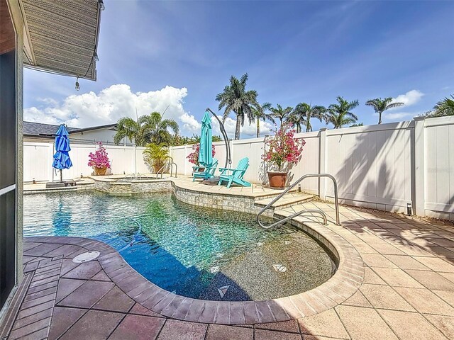 1120 81st St S, Saint Petersburg, FL 33707 - view of swimming pool with a patio area, a fenced backyard, and a pool with connected hot tub