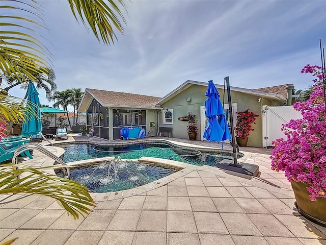 1120 81st St S, Saint Petersburg, FL 33707 - view of swimming pool featuring a sunroom, a pool with connected hot tub, a patio area, and a fenced backyard