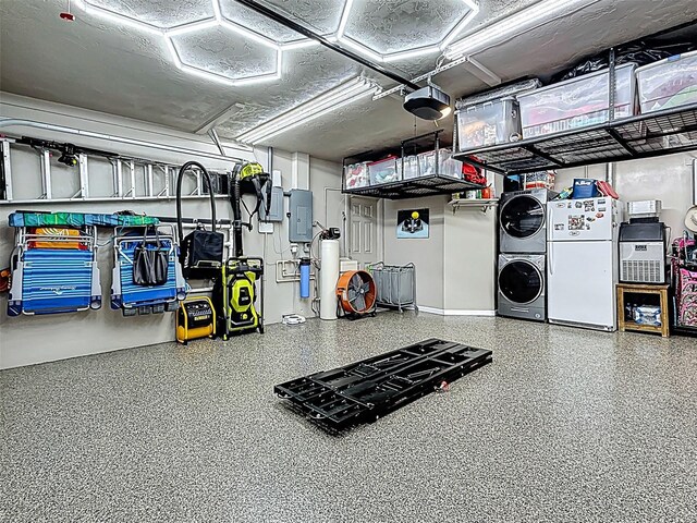 1120 81st St S, Saint Petersburg, FL 33707 - garage featuring stacked washer / dryer, freestanding refrigerator, a garage door opener, electric panel, and baseboards