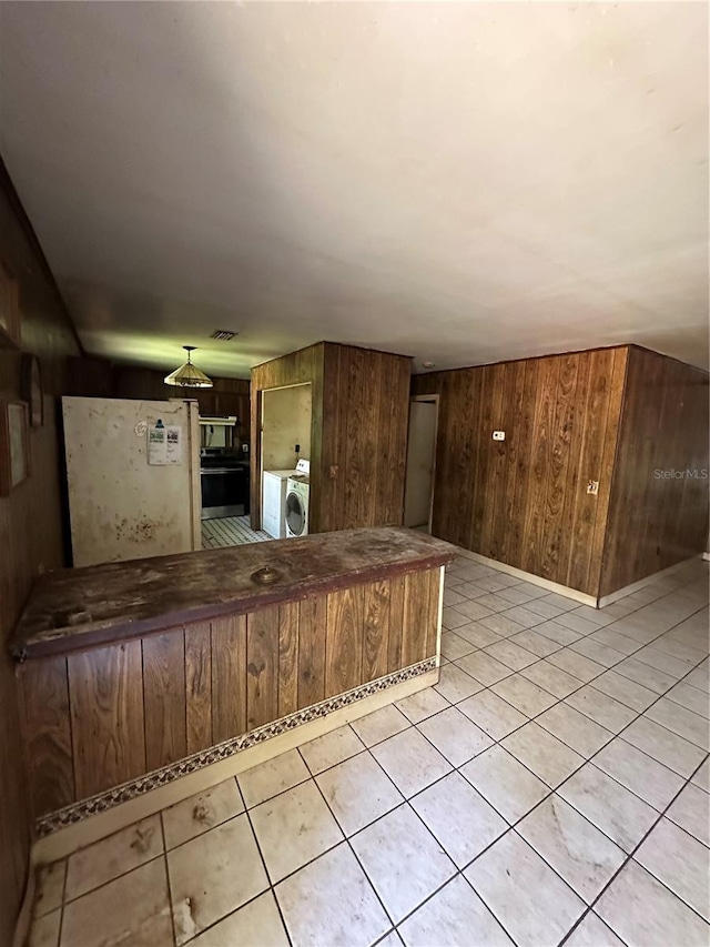 15750 NE 150th Ter, Fort Mc Coy, FL 32134 - kitchen with washer / dryer, wood walls, and light tile patterned floors