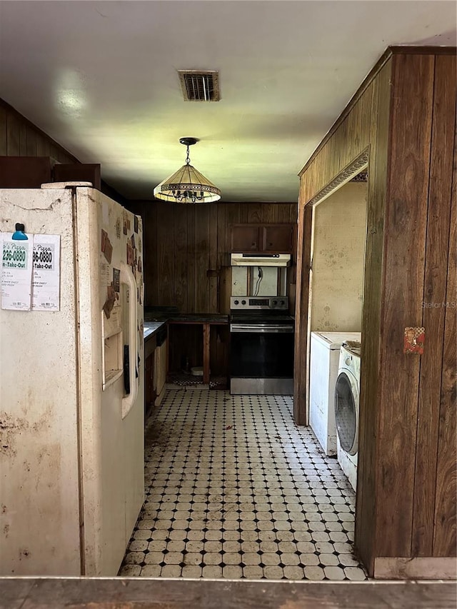 15750 NE 150th Ter, Fort Mc Coy, FL 32134 - kitchen featuring white refrigerator with ice dispenser, electric range, independent washer and dryer, wood walls, and light floors
