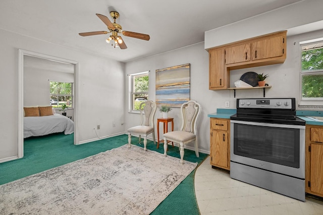 3233 SW 125th St, Archer, FL 32618 - kitchen with stainless steel range with electric cooktop, ceiling fan, light countertops, and baseboards