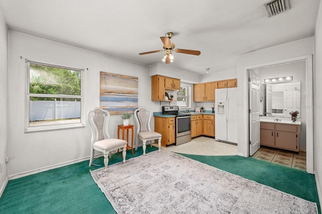 3233 SW 125th St, Archer, FL 32618 - kitchen with stainless steel range with electric cooktop, white fridge with ice dispenser, ceiling fan, baseboards, and light colored carpet
