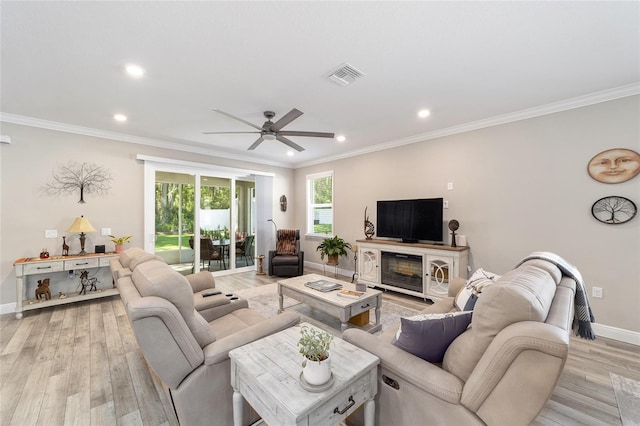 living area featuring a ceiling fan, light wood finished floors, baseboards, recessed lighting, and crown molding