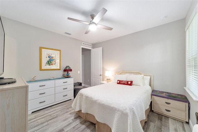 bedroom with light wood finished floors, baseboards, and ceiling fan