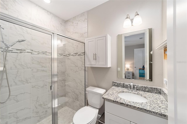 full bath with a stall shower, vanity, and toilet