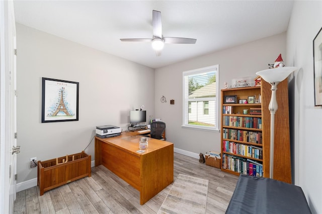 office space featuring a ceiling fan, light wood-style floors, and baseboards
