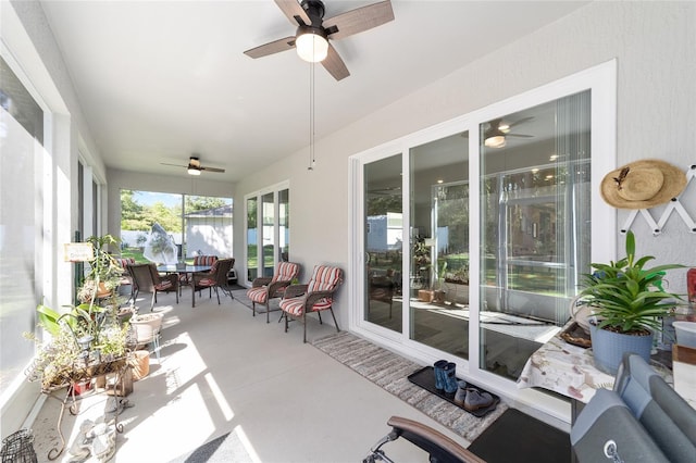 sunroom with a ceiling fan and outdoor dining space