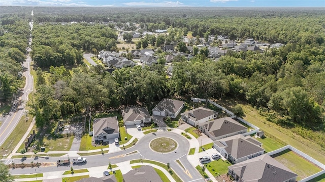view of property location featuring a forest and nearby suburban area