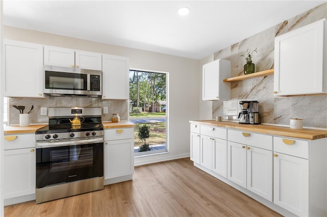 kitchen featuring appliances with stainless steel finishes, wooden counters, open shelves, decorative backsplash, and recessed lighting