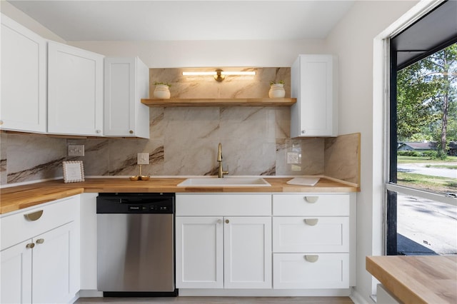 kitchen with stainless steel dishwasher, a sink, open shelves, and butcher block countertops
