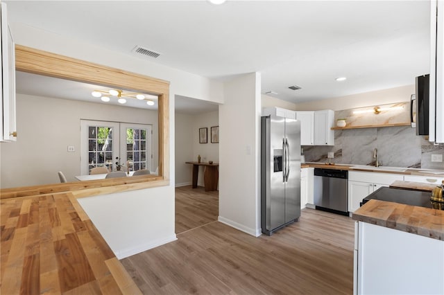 kitchen featuring stainless steel appliances, wooden counters, a sink, open shelves, and white cabinetry