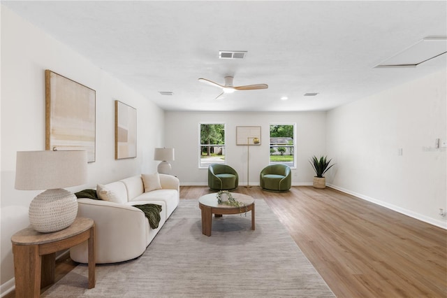 living area with wood finished floors, ceiling fan, and baseboards