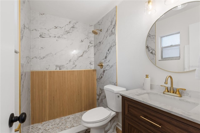 full bathroom with a marble finish shower, vanity, and toilet