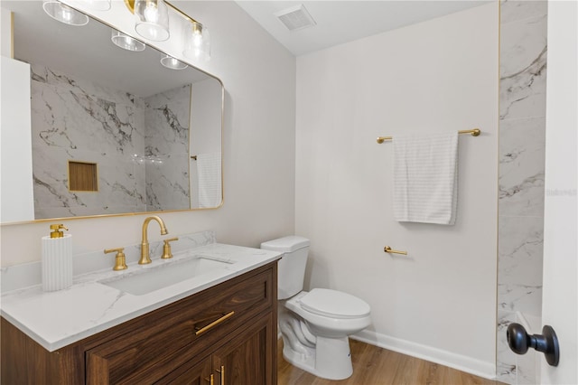 full bath featuring wood finished floors, toilet, vanity, and baseboards