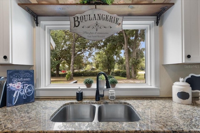 914 S Main St, Trenton, FL 32693 - kitchen view of a sink, white cabinetry, and light stone countertops