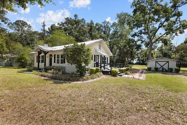 914 S Main St, Trenton, FL 32693 - view of side of property featuring a lawn, a chimney, metal roof, and a garage