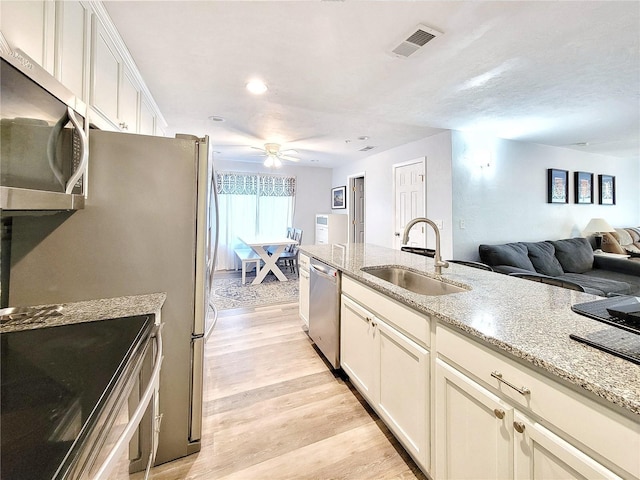 4000 SW 23rd St Unit 3-305, Gainesville, FL 32608 - kitchen featuring a sink, stainless steel appliances, light wood finished floors, ceiling fan, and light stone counters