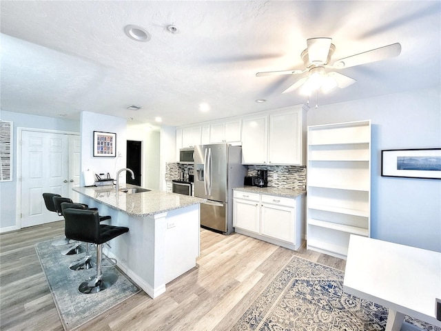 4000 SW 23rd St Unit 3-305, Gainesville, FL 32608 - kitchen with stainless steel appliances, a sink, white cabinetry, decorative backsplash, and recessed lighting