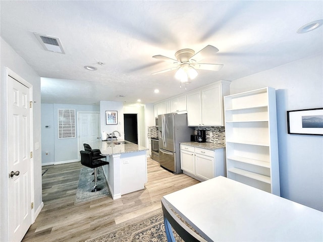 4000 SW 23rd St Unit 3-305, Gainesville, FL 32608 - kitchen featuring appliances with stainless steel finishes, white cabinets, a ceiling fan, light wood-style floors, and a sink