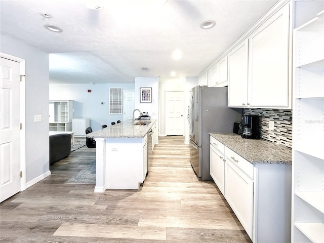 4000 SW 23rd St Unit 3-305, Gainesville, FL 32608 - kitchen with a sink, open shelves, white cabinetry, light wood-style floors, and appliances with stainless steel finishes