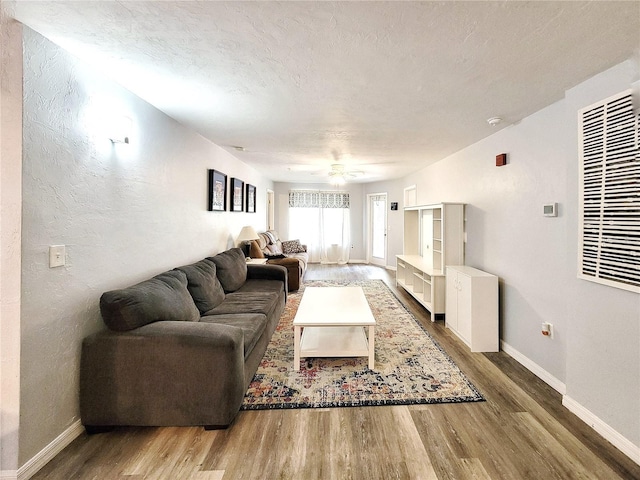 4000 SW 23rd St Unit 3-305, Gainesville, FL 32608 - living room with wood finished floors, baseboards, a ceiling fan, and a textured ceiling
