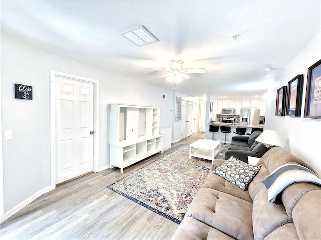 4000 SW 23rd St Unit 3-305, Gainesville, FL 32608 - living room with light wood-type flooring, ceiling fan, and baseboards