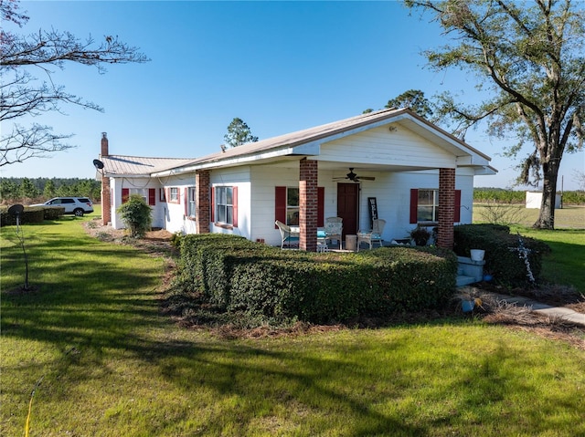 1058 NW County Road 290, Mayo, FL 32066 - view of front of house with ceiling fan, a chimney, a front yard, and covered porch