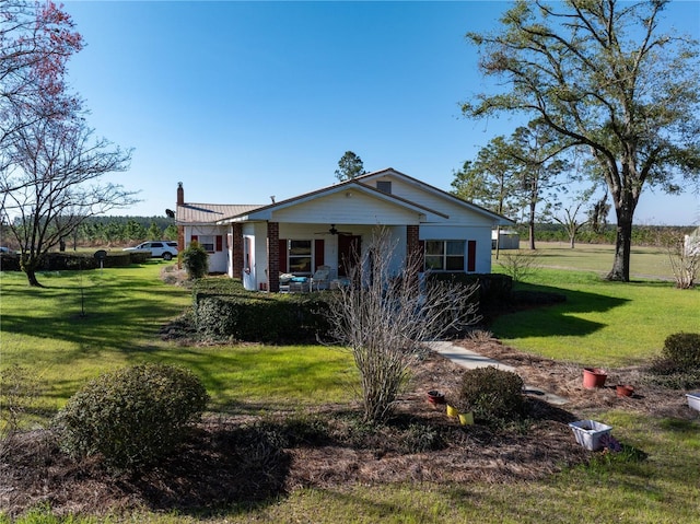 1058 NW County Road 290, Mayo, FL 32066 - view of front of home featuring ceiling fan, a front yard, a chimney, covered porch, and brick siding