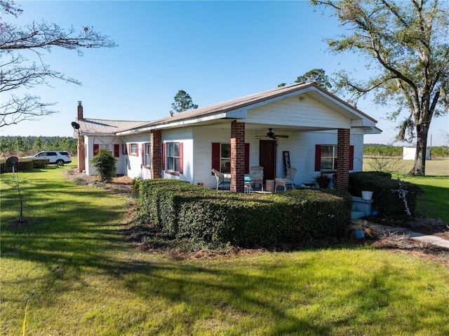 1058 NW County Road 290, Mayo, FL 32066 - view of front of house featuring ceiling fan, a chimney, and a front yard