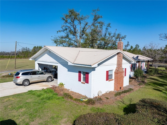 1058 NW County Road 290, Mayo, FL 32066 - view of side of property with a chimney, a lawn, a garage, and driveway