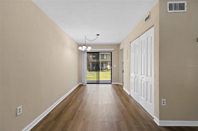 2300 SW 43rd St Unit Q2, Gainesville, FL 32607 - unfurnished dining area with a chandelier, wood finished floors, and baseboards