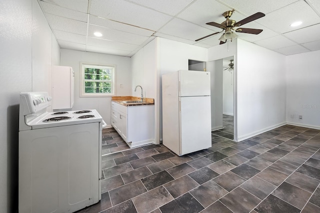 3046 SE 134th St, Starke, FL 32091 - kitchen featuring white appliances, a sink, a paneled ceiling, ceiling fan, and white cabinets