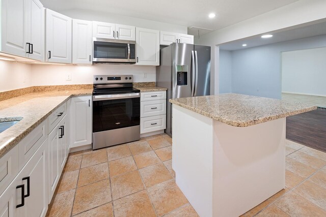 3046 SE 134th St, Starke, FL 32091 - kitchen with appliances with stainless steel finishes, white cabinetry, recessed lighting, light stone countertops, and a kitchen island