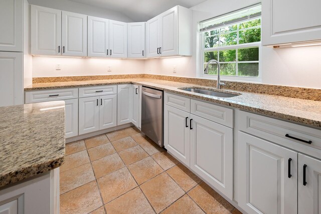 3046 SE 134th St, Starke, FL 32091 - kitchen featuring a sink, stainless steel dishwasher, white cabinets, light stone counters, and light stone finish floors