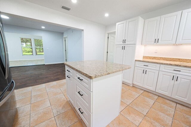 3046 SE 134th St, Starke, FL 32091 - kitchen with recessed lighting, light stone countertops, a center island, white cabinetry, and freestanding refrigerator