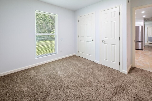 3046 SE 134th St, Starke, FL 32091 - unfurnished bedroom with freestanding refrigerator, carpet, baseboards, multiple closets, and recessed lighting