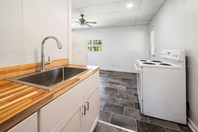 3046 SE 134th St, Starke, FL 32091 - kitchen with electric stove, butcher block counters, a sink, a ceiling fan, and white cabinetry
