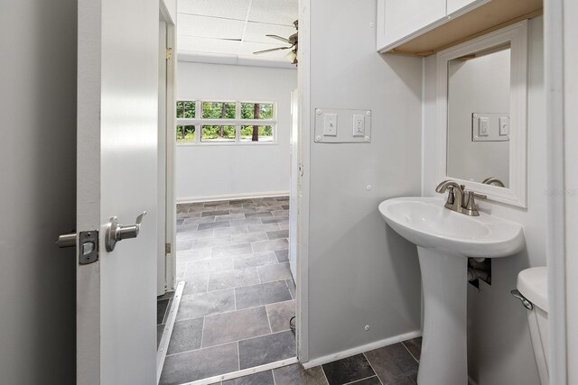 3046 SE 134th St, Starke, FL 32091 - half bath with baseboards, stone finish flooring, a ceiling fan, a sink, and toilet
