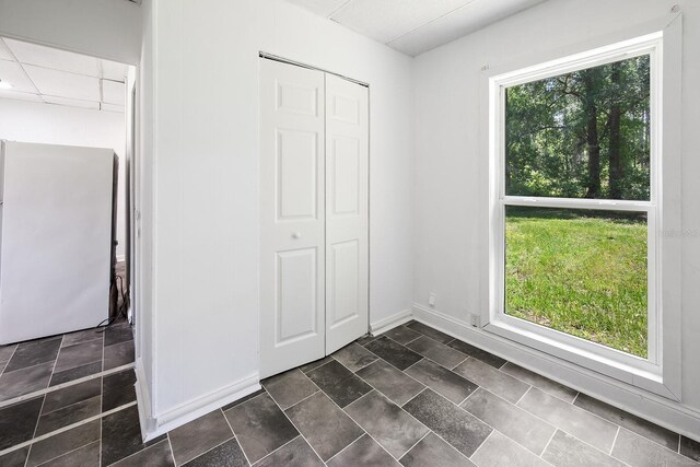 3046 SE 134th St, Starke, FL 32091 - unfurnished bedroom featuring freestanding refrigerator, a closet, and baseboards