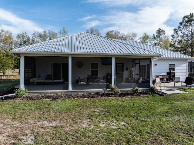 11001 225th Rd, Live Oak, FL 32060 - back of house with a sunroom, a lawn, metal roof, a standing seam roof, and a patio